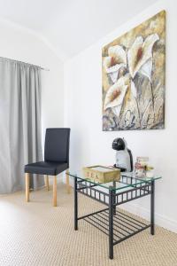 a living room with a glass table and a chair at The Willows House & Studios in Limavady