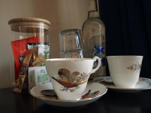 two cups and saucers sitting on a table at Painters at the Angel in Sudbury