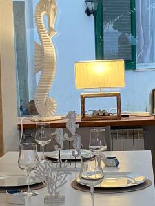 un tavolo con bicchieri da vino e una scultura di cavalluccio marino di Ippocampo Blanc a San Felice Circeo
