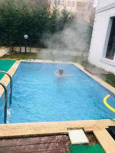un homme se baignant dans une piscine avec un bain à vapeur dans l'établissement Sapanca Manzara Villa 1 Isıtma Havuzlu, à Sapanca