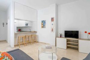 ein Wohnzimmer mit einem Glastisch und eine Küche in der Unterkunft Santa Cruz Parking incluido in Sevilla