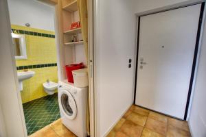 a bathroom with a washing machine and a washer at Bello Pianello Lake View Apartment in Pianello Del Lario