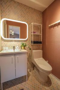 een badkamer met een toilet, een wastafel en een spiegel bij ZDT-614 in Tokyo