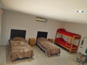 Habitación con 2 camas y silla roja. en Simplicity Apart en San Rafael