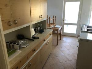kuchnia z drewnianymi szafkami i podłogą wyłożoną kafelkami w obiekcie Sajó Vendégház w mieście Sajószöged +13 zdjęć