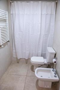 łazienka z toaletą i białą zasłoną prysznicową w obiekcie Un ambiente frente al mar w mieście Mar del Plata