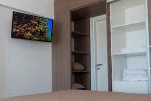 a bedroom with a bed with a tv on a wall at Un ambiente frente al mar in Mar del Plata