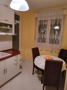 a kitchen and dining room with a table and chairs at Apartman Sunce in Podgorica