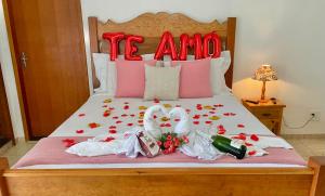 Una cama con dos cisnes y flores. en Pouso das Flores -350m Maria Fumaça, en Tiradentes
