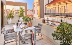 a balcony with a table and chairs on a balcony at Hôtel Barrière Le Gray d'Albion in Cannes