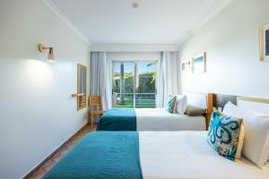 a hotel room with two beds and a window at Pontalaia Apartamentos Turísticos in Sagres