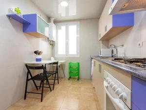 una cocina con armarios azules y una mesa pequeña en Click&Flat Fira Castelao, en Hospitalet de Llobregat