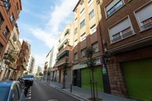 een straat met gebouwen met groene garagedeuren bij Click&Flat Fira Castelao in Hospitalet de Llobregat