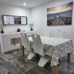 a dining room with a table and chairs and a painting at Nandos Apartement in Costa da Caparica