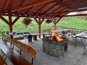 a fire pit in a patio with tables and benches at SCHRONISKO GOŚCINIEC RÓWNICA in Ustroń