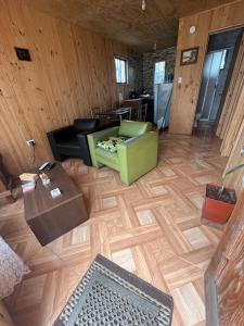 - un salon avec un canapé vert et du parquet dans l'établissement Cabañas akrilu, à Puchuncaví