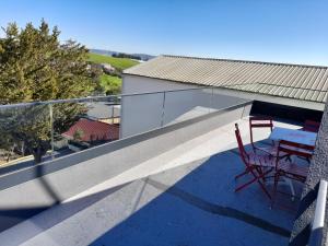 a balcony with a table and chairs on it at Hall 92 Quartos com WC em moradia com piscina A-das-Lebres Loures in Loures