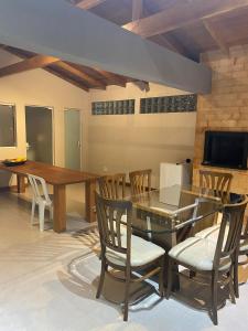 a dining room with a glass table and chairs at Casa Temporada in Camboriú +5 photos