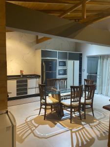 a dining room with a table and chairs in a kitchen at Casa Temporada in Camboriú
