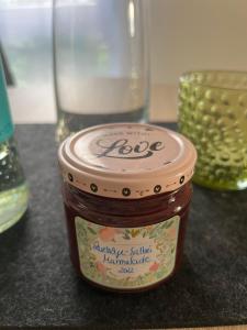 a jar of jam sitting on a table with a glass at Apartment centrally located in the Rhine-Main area in Riedstadt