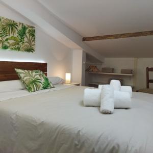 um quarto com uma cama branca e toalhas em las llaves del arca em Trujillo