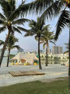 Tienda blanca en una playa con palmeras en R102 Vinhomes Ocean Park homestay en Hanoi