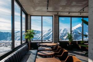 a restaurant with tables and chairs and mountains at Hotel Carpe Diem Gudauri in Gudauri