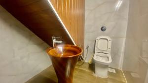 a bathroom with a wooden toilet and a sink at Willo Stays Luxe Heritage Home , Udupi in Udupi +62 photos