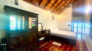 una camera con letto, tavolo da trucco e specchio di Willo Stays Luxe Heritage Home , Udupi a Udupi