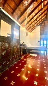 a room with a bed and a table and a floor at Willo Stays Luxe Heritage Home , Udupi in Udupi