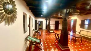un corridoio con sedie e orologio sul muro di Willo Stays Luxe Heritage Home , Udupi a Udupi
