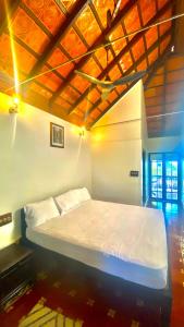 a large bed in a room with a wooden ceiling at Willo Stays Luxe Heritage Home , Udupi in Udupi