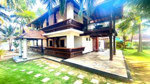 una grande casa con un cortile di fronte di Willo Stays Luxe Heritage Home , Udupi a Udupi