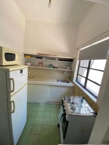 eine Küche mit einem weißen Kühlschrank und einem Fenster in der Unterkunft Alojamiento Barrio Sur in Colonia del Sacramento