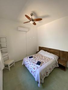 1 dormitorio con 1 cama y ventilador de techo en Alojamiento Barrio Sur en Colonia del Sacramento