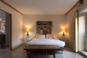 アスカンにあるHotel Alaïaのベッドルーム1室(ベッド1台、ランプ2つ、テーブル付)