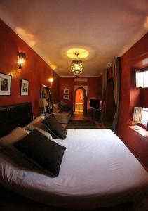 sypialnia z dużym białym łóżkiem z czerwonymi ścianami w obiekcie Riad Dar Teranga Hotel & Spa w Marakeszu
