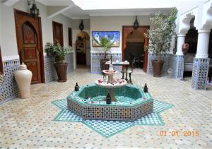 a building with a fountain in the middle of a room at Riad Dar Teranga Hotel & Spa in Marrakech