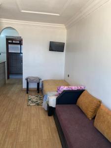 a room with a couch and a tv on a wall at Apartamentos EL BARCO in Sidi Ifni