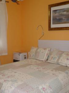 a bedroom with a bed and a picture on the wall at Habitaciones en Aviles in Avilés