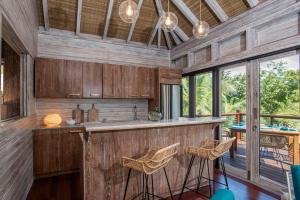 a kitchen with wood paneling and a bar with stools at The Hideout in Jost Van Dyke