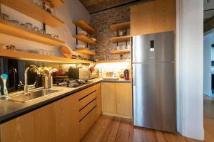 uma cozinha com um frigorífico de aço inoxidável e armários de madeira em Historic Loft w/Terrace and Old Istanbul View em Istambul