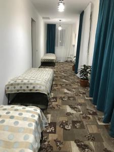 3 posti letto in una camera con tende blu di Гостевой дом a Karakol
