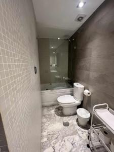 a bathroom with a toilet and a tub and a sink at Ático San Bernardo Terraza y Parking Incluido in Seville