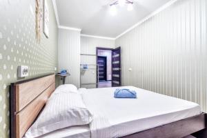 1 dormitorio con 1 cama grande con sábanas blancas en Edem Palas 2, en Astana