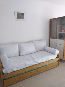 a couch with white pillows sitting in a room at Departamento centrico-Vivi Bariloche todo el año in San Carlos de Bariloche