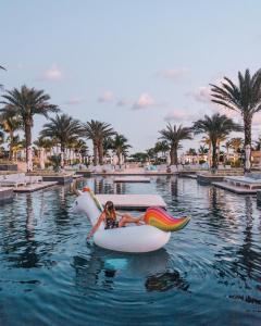 a woman riding on an unicorn in the water at a resort at Unico Hotel Riviera Maya Adults Only in Akumal