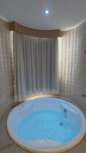 a large tub in a bathroom with a window at Apartamento luxo Hot Springs Caldas Novas tay in Caldas Novas