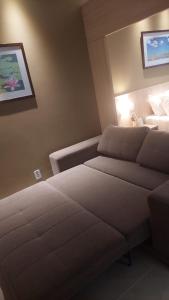 Habitación de hotel con 2 camas y sofá en Apartamento luxo Hot Springs Caldas Novas tay, en Caldas Novas
