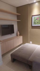 a bedroom with a bed and a flat screen tv at Apartamento luxo Hot Springs Caldas Novas tay in Caldas Novas